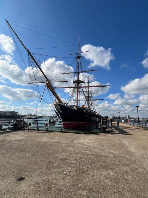       A historic ship docked at a harbor.
  