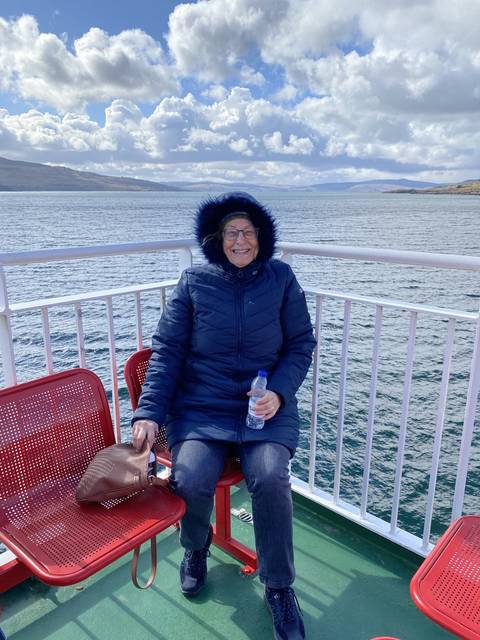 Person sitting on a ferry with a water bottle.