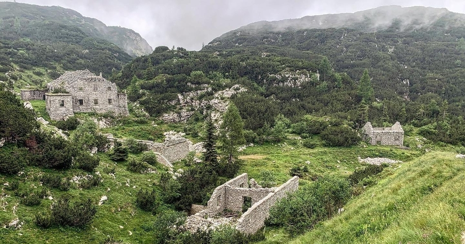 Ruins in a mountainous landscape under an overcast sky.