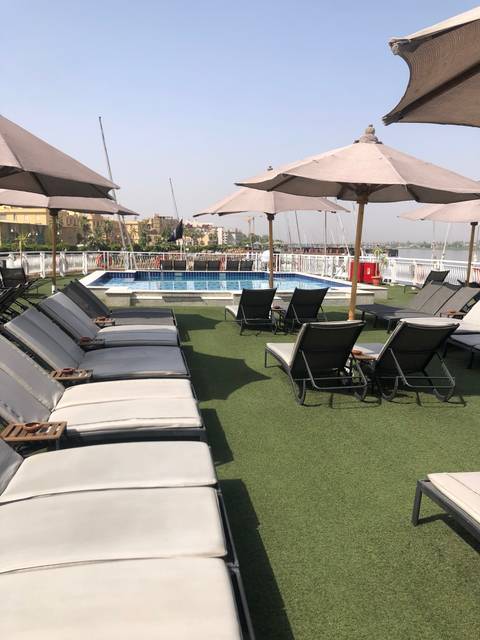 Poolside view with lounge chairs and sun umbrellas.
