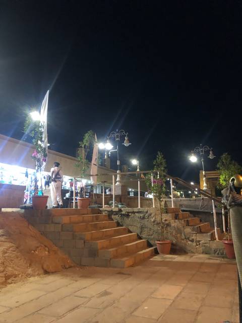       Night market with street lights and people.
  