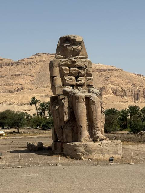       Ancient statue against a desert backdrop.
  