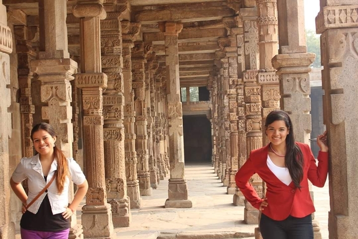 Two women posing in an ancient columned hallway