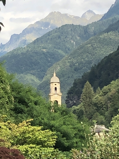 Scenic view of a bell tower amidst green hills.