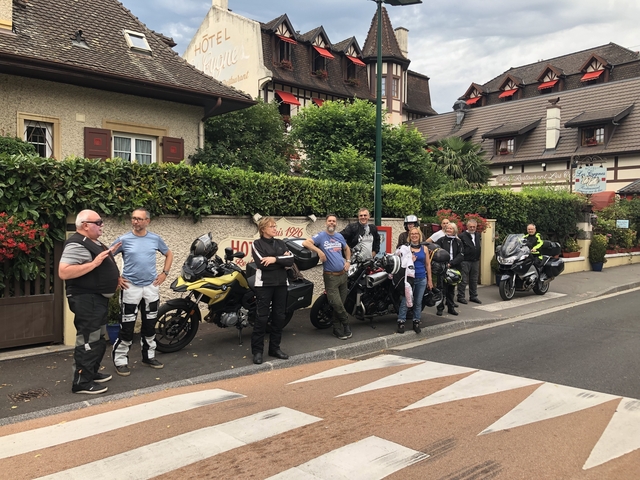 Motorcycle group on the street in front of a traditional building.