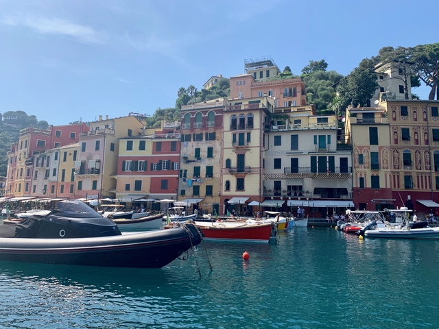Colourful buildings by a waterfront with boats docked.