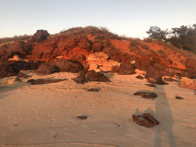 Coastal landscape with rocks and sandy beach.