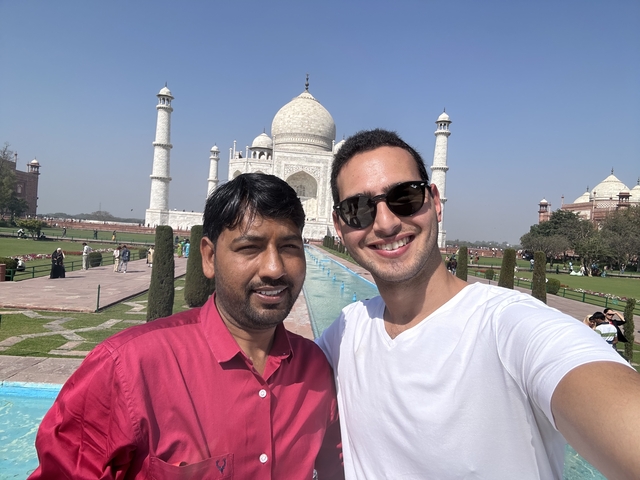 Two people taking a selfie in front of the Taj Mahal.