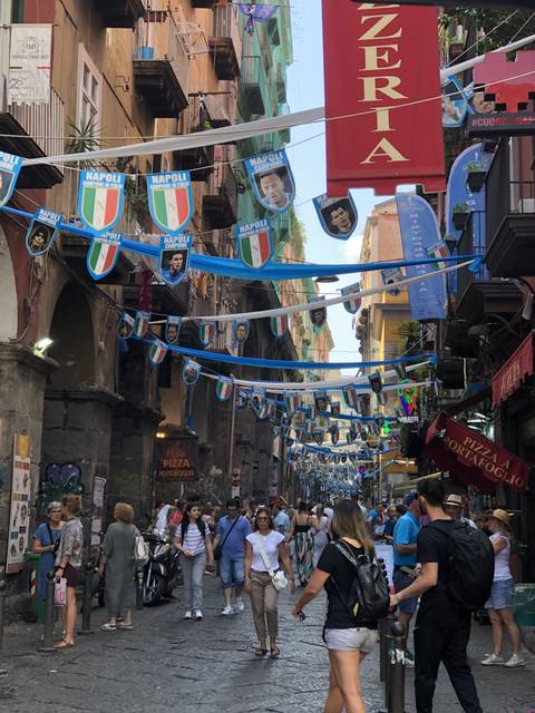       Busy street with hanging decorations and banners.
  