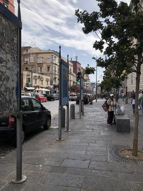       Busy street with pedestrians and storefronts.
  