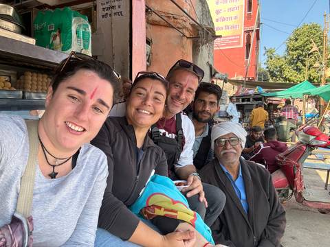 A group of people posing in a vibrant market setting.