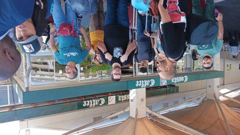       People standing outside a store in an outdoor setting.
  