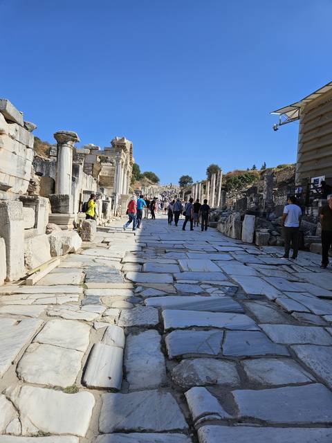       Ancient ruins with people walking through.
  