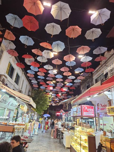       Colorful umbrellas hanging in a street market.
  