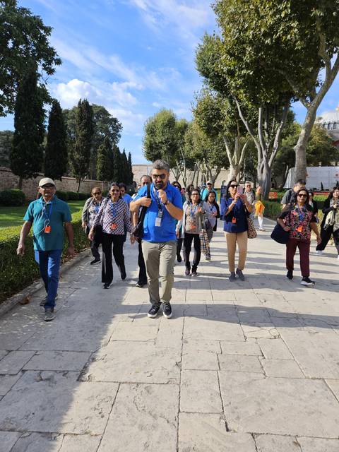       Group of tourists walking outside.
  