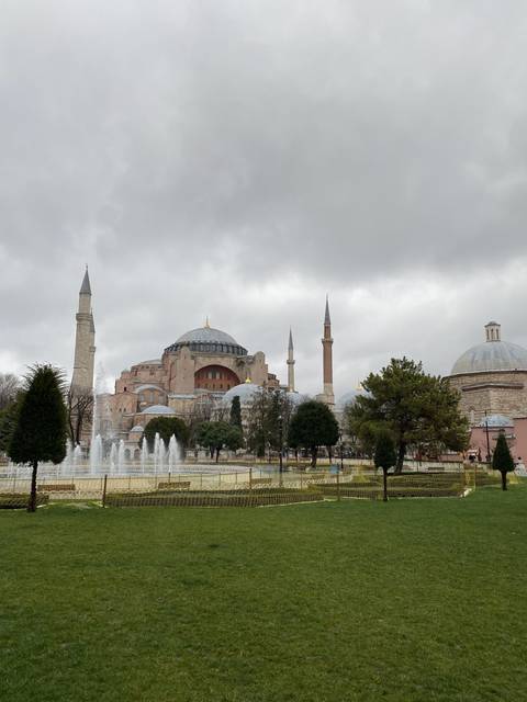 View of a historic mosque seen across a fountain.
