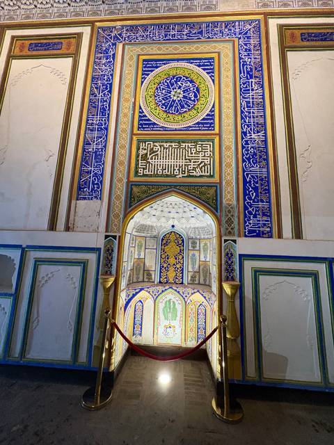       Ornate interior with intricate tilework and calligraphy.
  