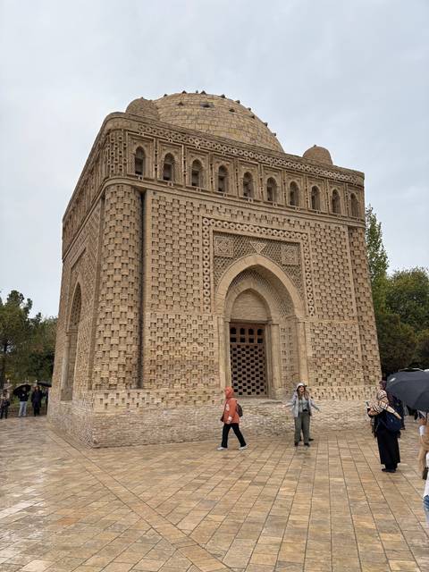       Visitors in front of a historic building with intricate brick patterns.
  