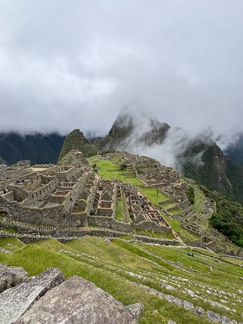       View of Machu Picchu with clouds in the background.
  