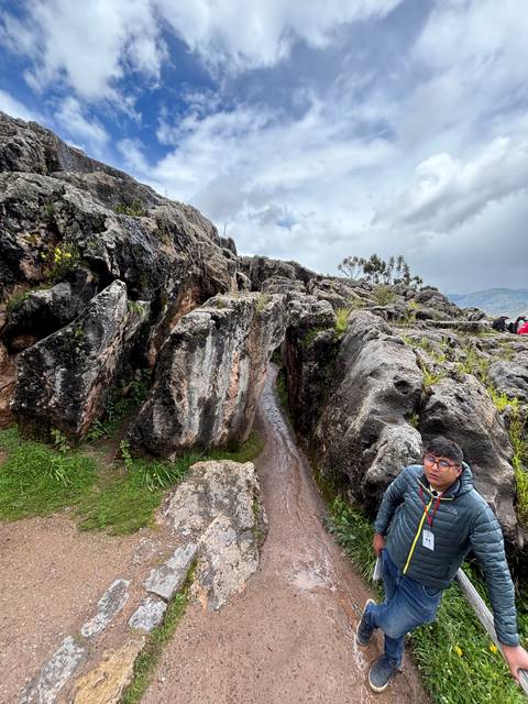 Person standing on rocky terrain with a smile.