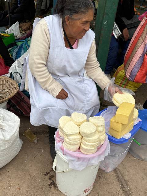       Woman selling cheese at a street market.
  
