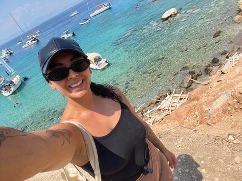 Woman smiling with a coastal background.