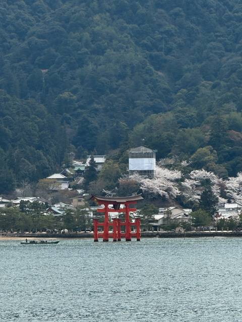 An iconic red torii gate standing near the shoreline.