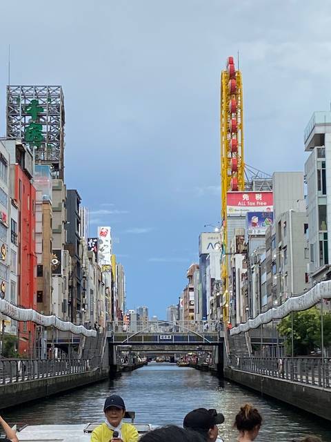       Busy canal area with iconic yellow ferris wheel.
  