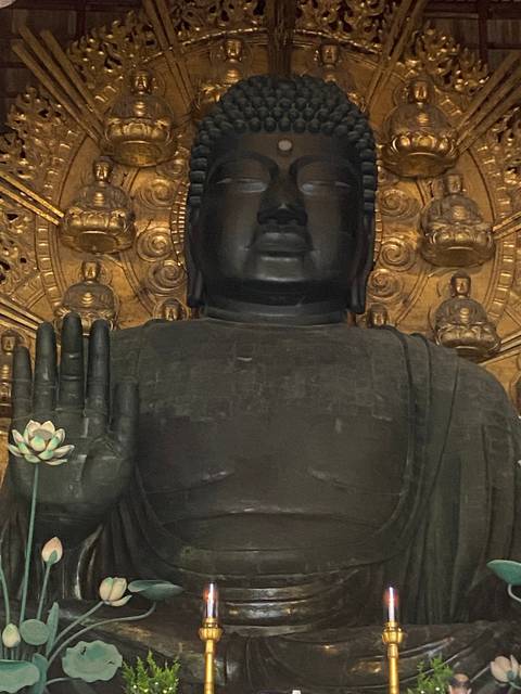 Large Buddha statue with intricate background.