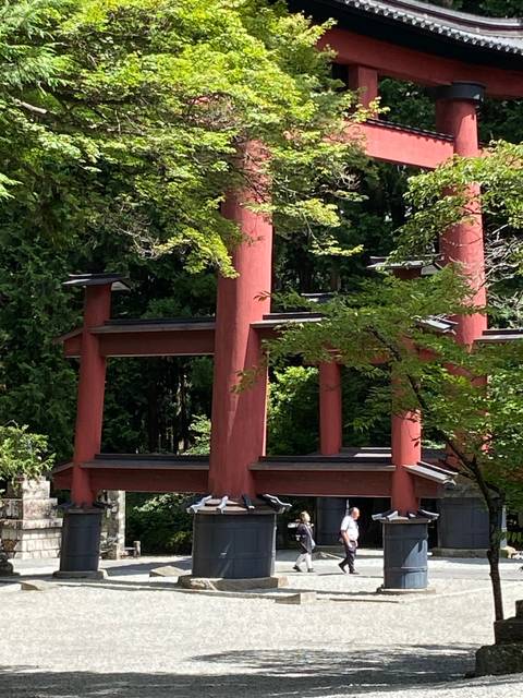 Two people beside a large torii gate.