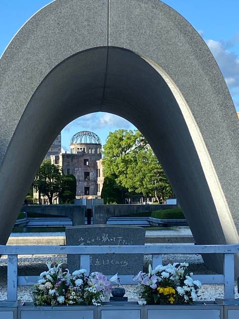 Memorial monument with arch and dome building in background.