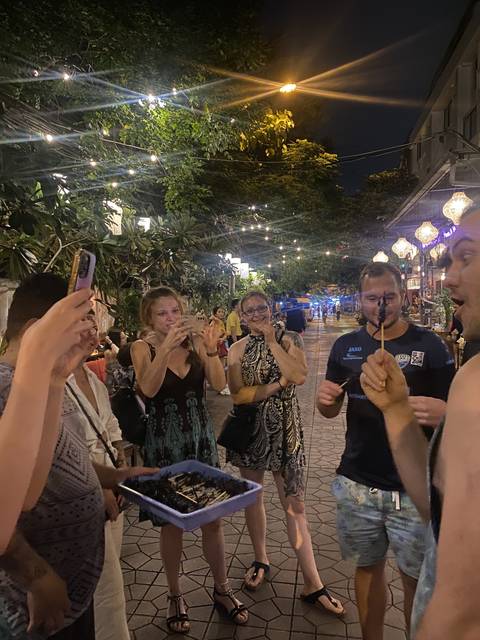 People eating street food at a night market.