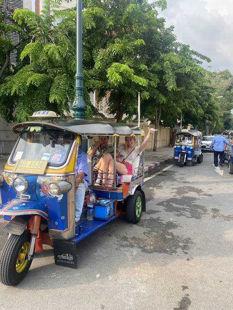 People riding in a tuk-tuk.