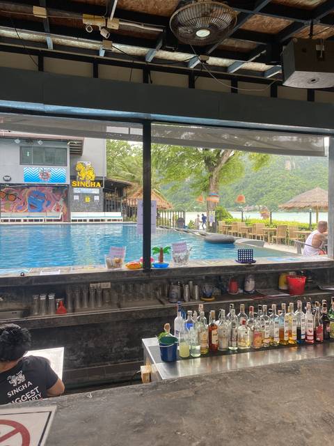 Pool bar with bottles and a view of a pool.