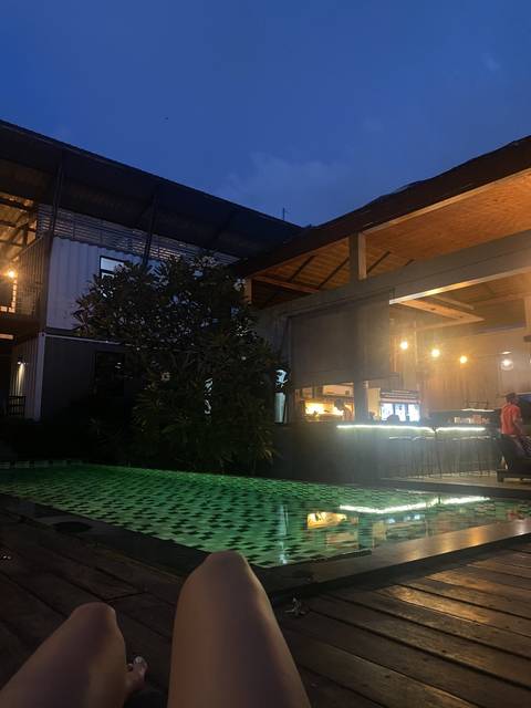 Evening view from a terrace overlooking a pool.