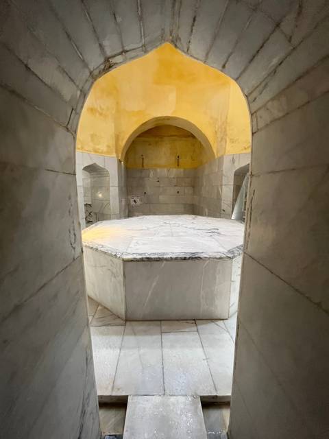       Interior of a traditional bath with marble finishes.
  