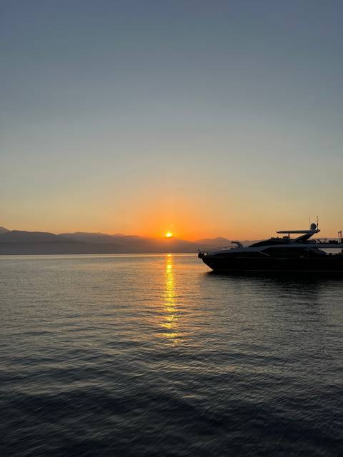       Luxurious yacht silhouetted against a sunset on the water.
  
