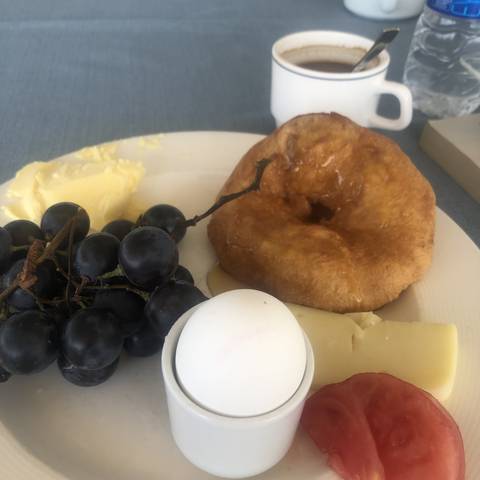       A variety of breakfast items including bread and grapes on a plate.
  