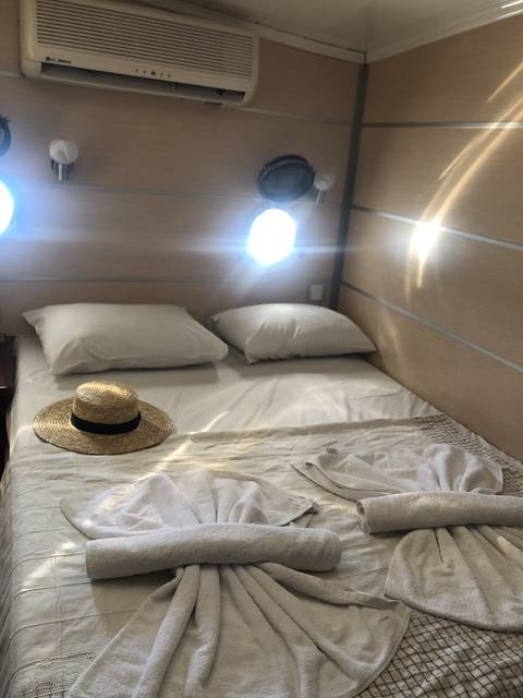       Interior of a boat or cabin with beds and towels.
  