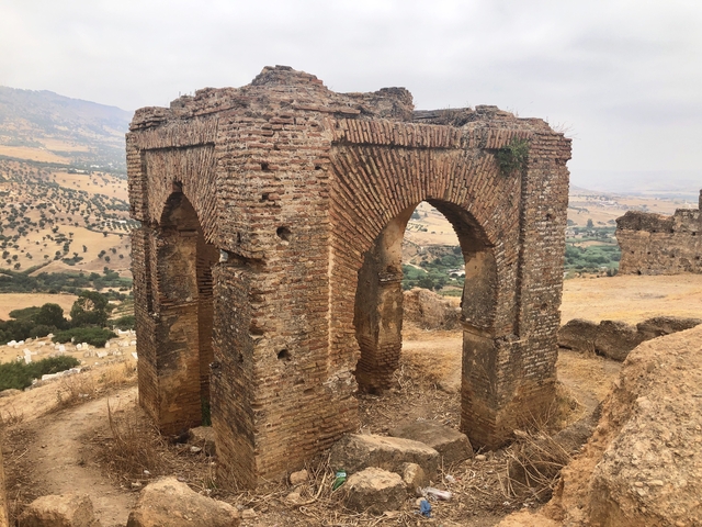       Ruins of an ancient structure on a hill with scenic views.
  