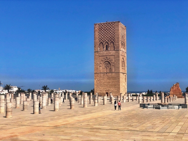 Hassan Tower in Rabat with surrounding columns and tourists.