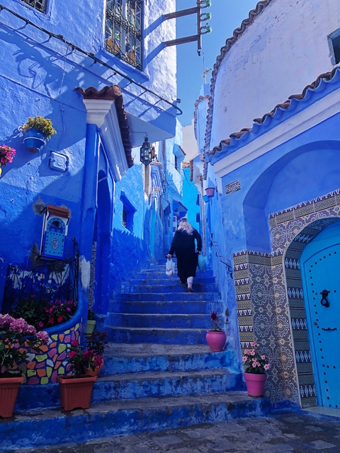 A blue-painted street in Chefchaouen with decorative tiles.