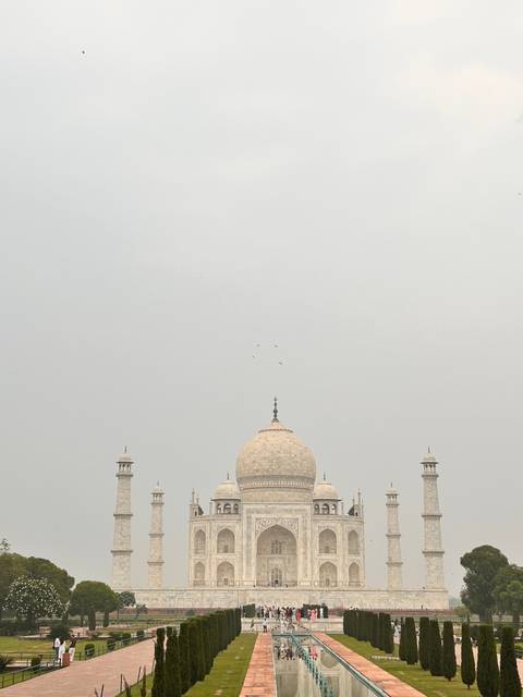       Majestic view of the Taj Mahal with its gardens.
  
