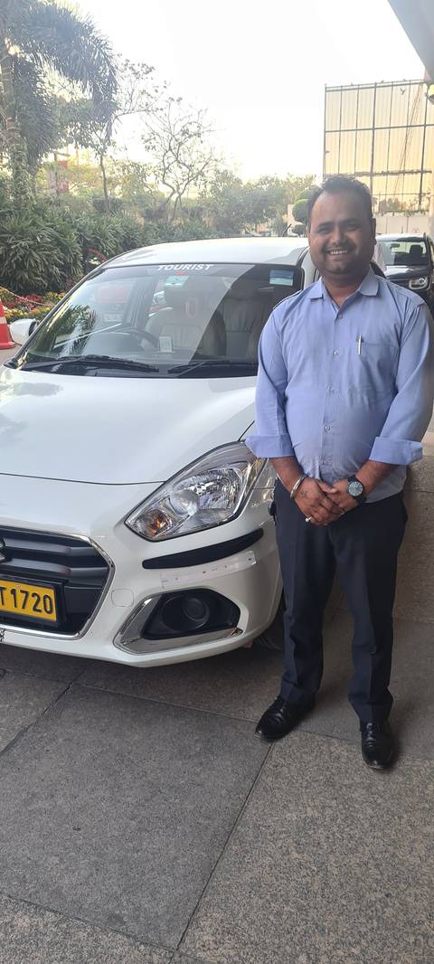 Person standing by a white car on a paved area.