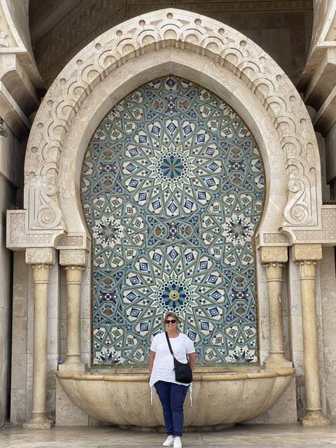 Person standing beside intricate tile work.