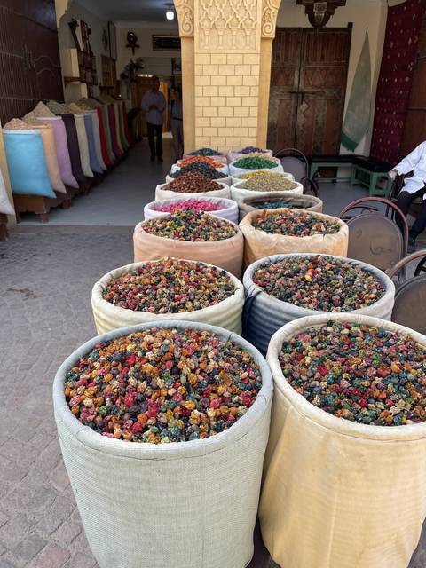 Colorful baskets of spices displayed in an open-air market.