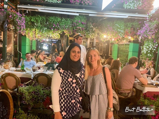       People dining in a vibrant, flower-adorned restaurant.
  