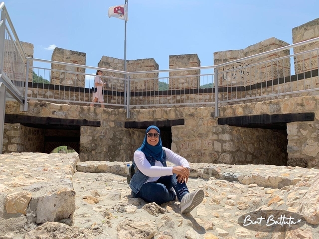 A person sitting on the rocks of a fortified structure.
