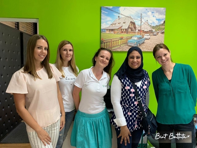       Group of women posing in front of a vibrant wall.
  