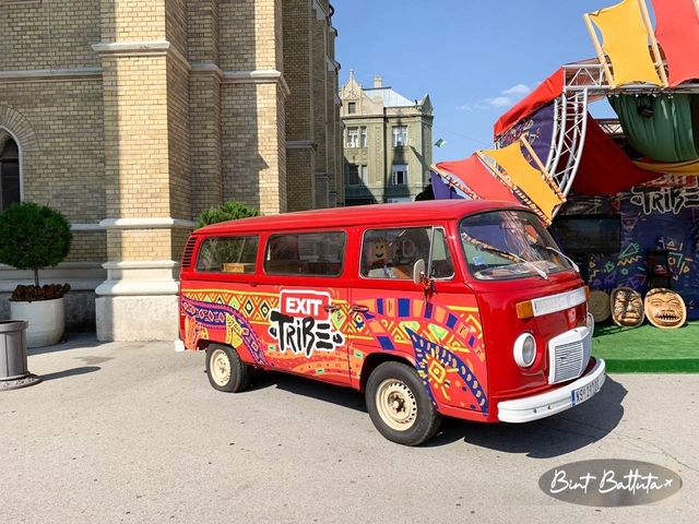       A colorful van parked in front of an urban building.
  